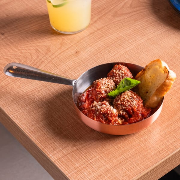 Doppio Zero's Italian meatballs in tomato sauce with parmesan, basil, and toasted bread.