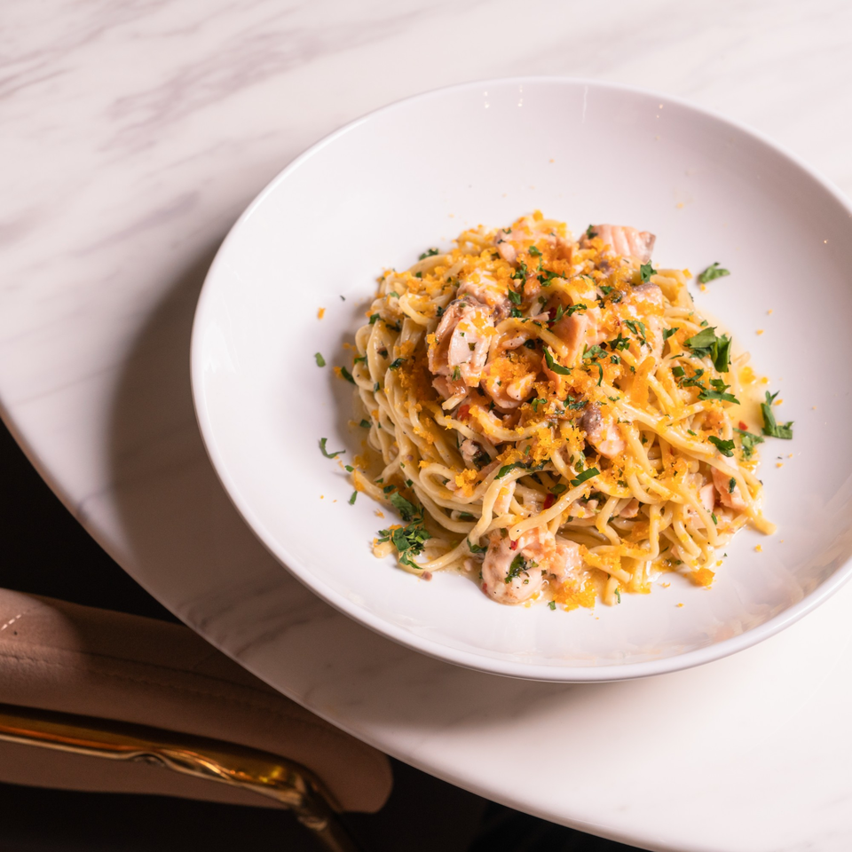 Doppio Zero's spaghetti with shrimp, mushrooms, and orange breadcrumbs, garnished with parsley.